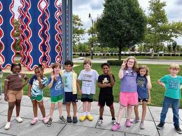 students standing outside of a museum